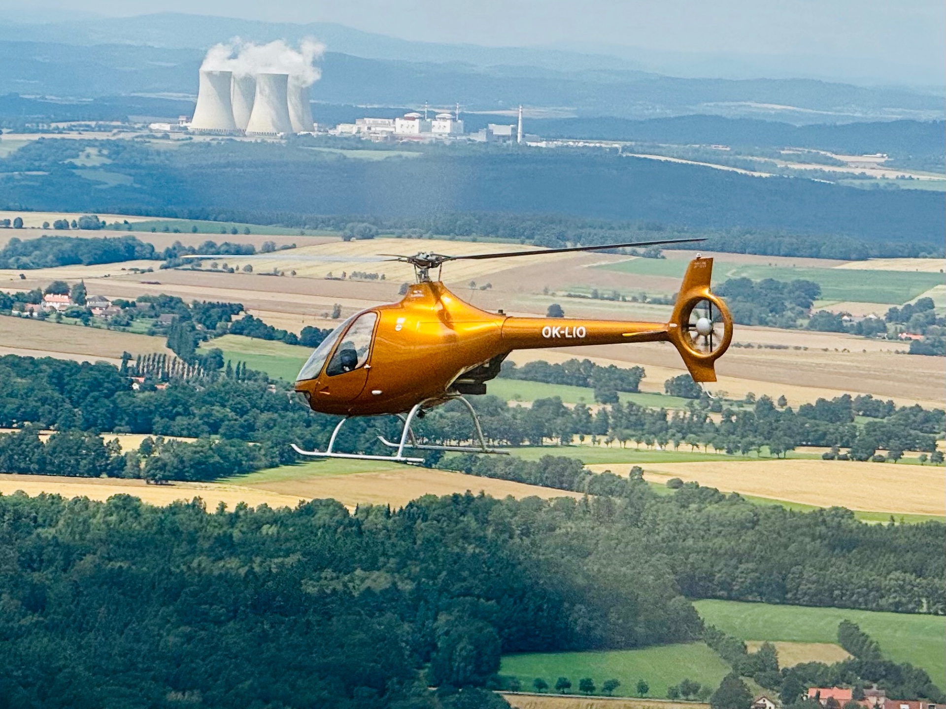 Vrtulník Guimbal Cabri G2 letící při západu slunce